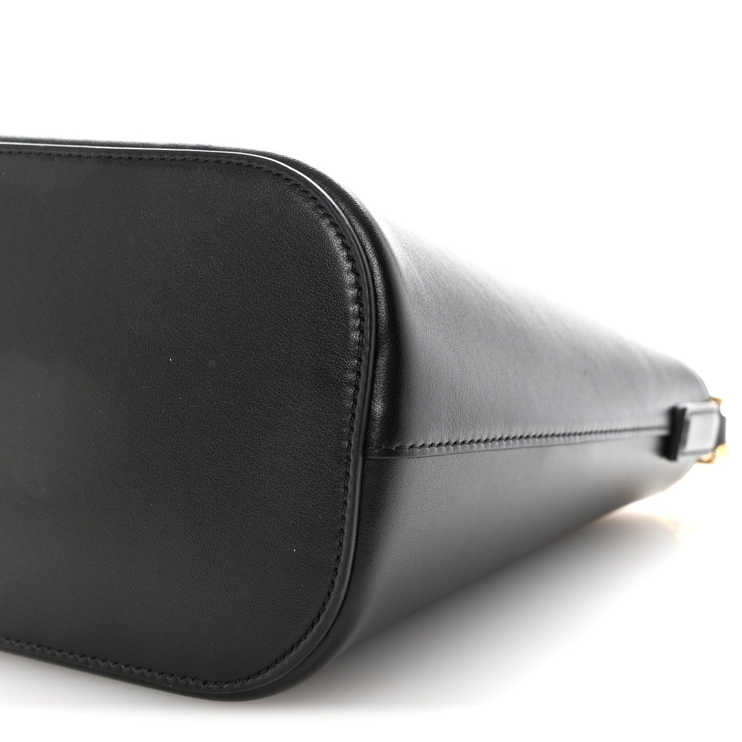 Close-up of black leather bag corner with stitching and gold-tone clasp hardware