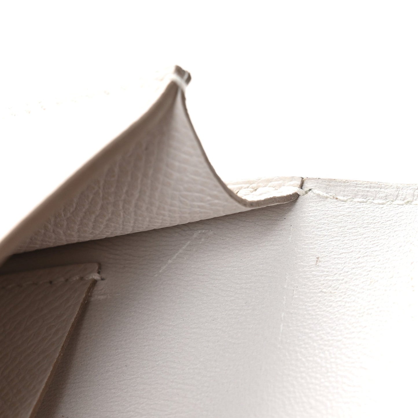 Pale gray leather interior seam detail of a slim wallet.
