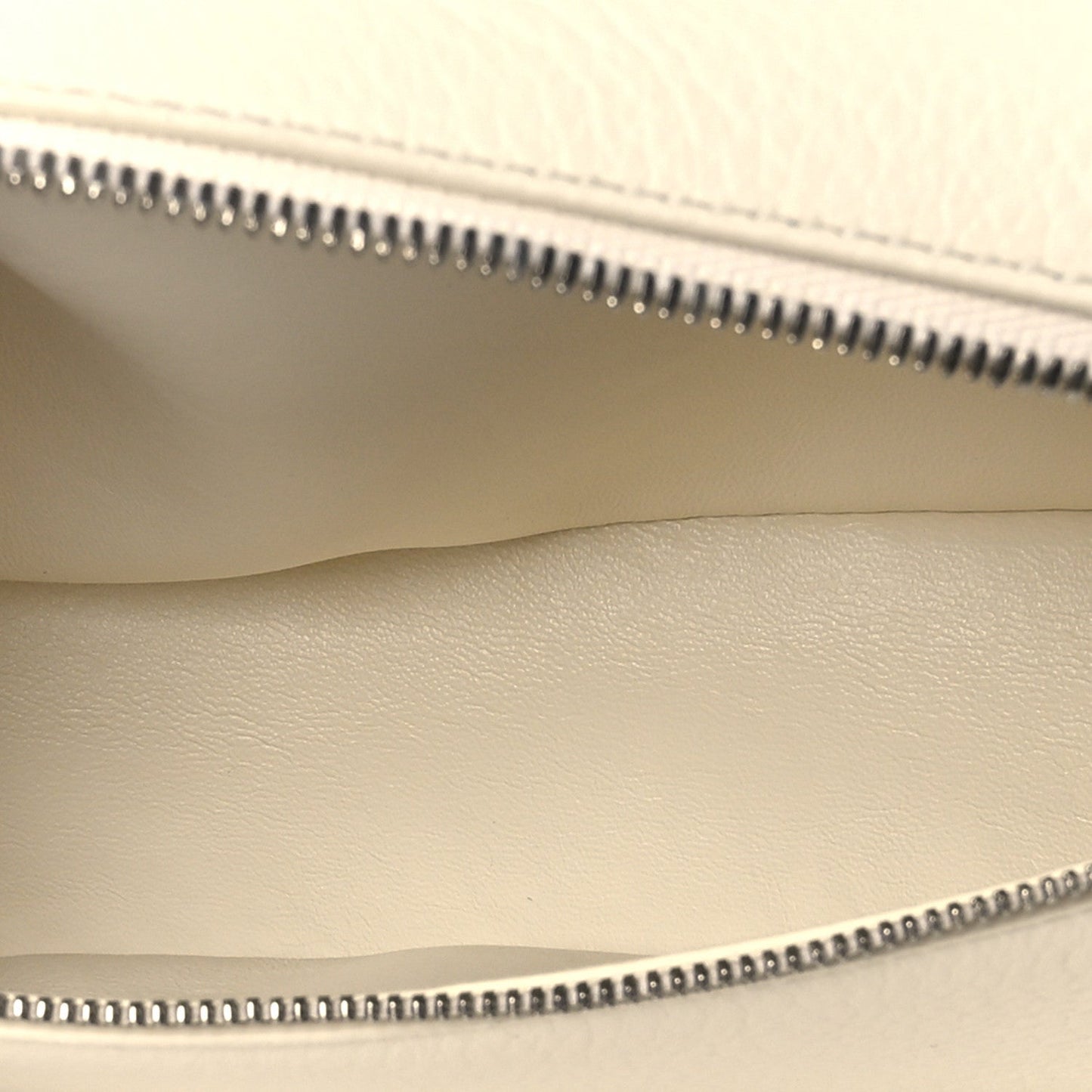 Pouch interior view showing zipper track, smooth lining, and grained leather edge