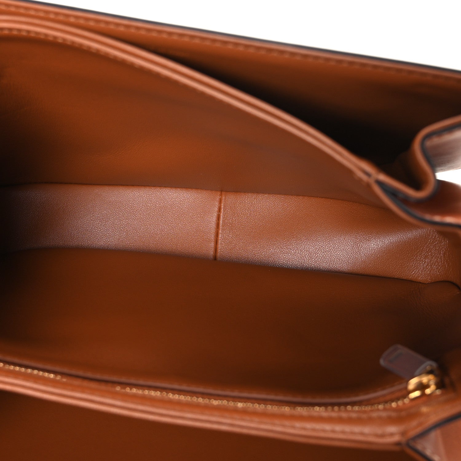 Tan leather shoulder bag interior panel with stitched seams and edge finishing detail.