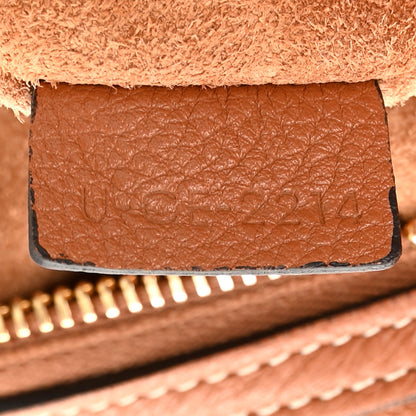 Tan leather interior panel with embossed stamp and visible contrast stitching