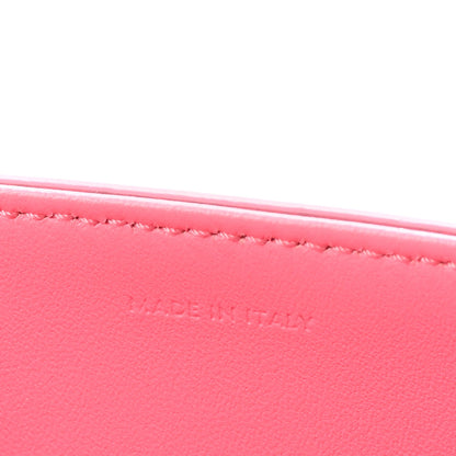 Flamingo pink leather with fine edge stitching along the top rim