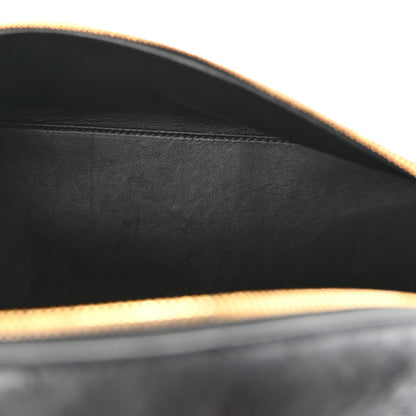 Close-up of black ostrich leather interior edge with gold-tone trim and smooth lining