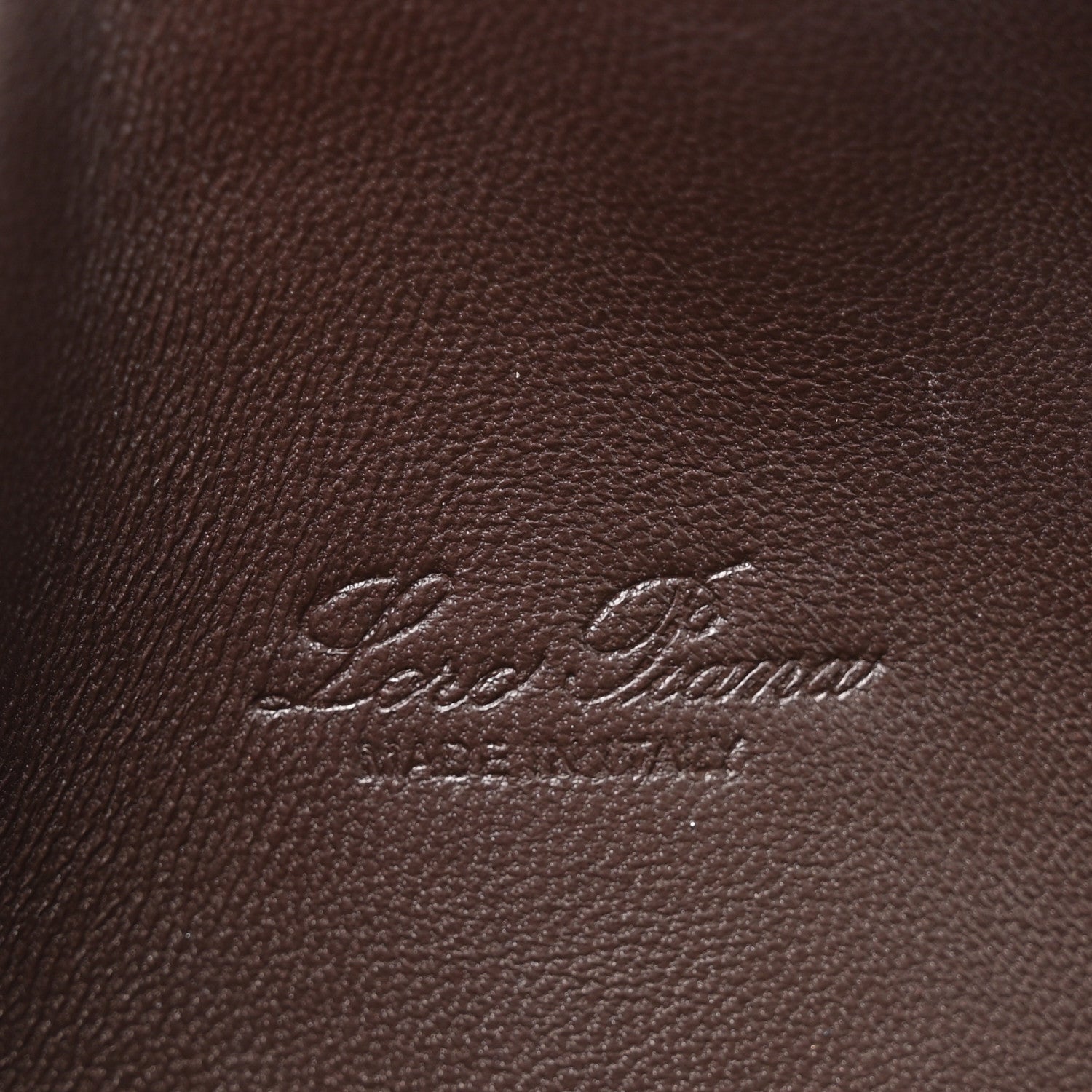 Loro Piana logo embossed on dark brown lizard leather pouch surface