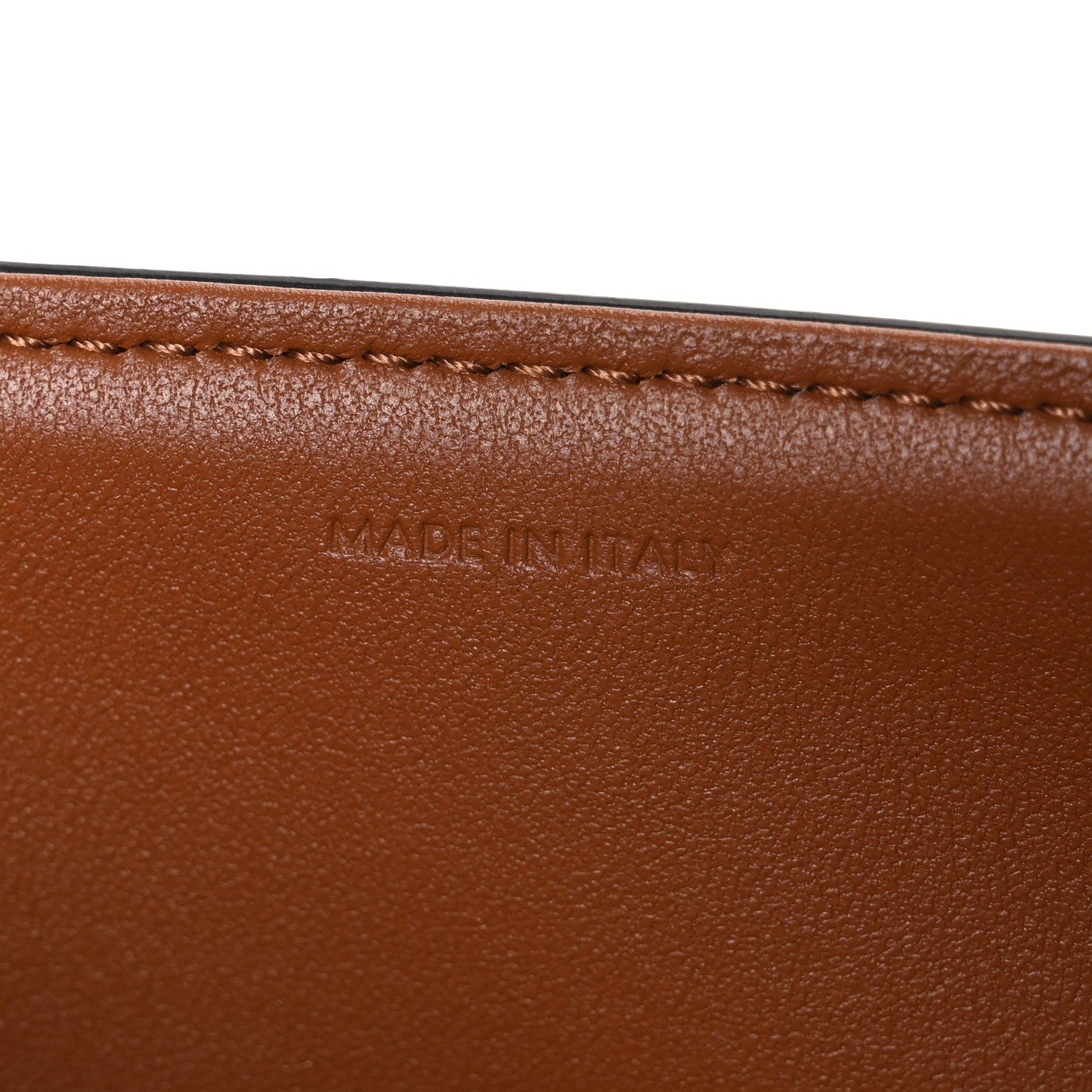 Tan leather edge with “MADE IN ITALY” stamped text and stitched border.