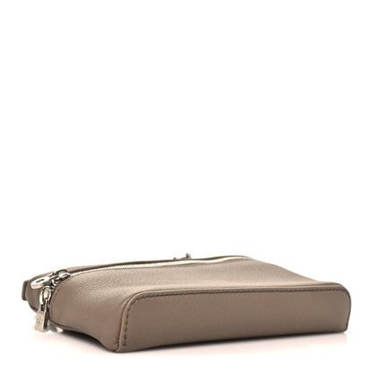 Mini leather pouch with top zipper and rounded base, viewed from side