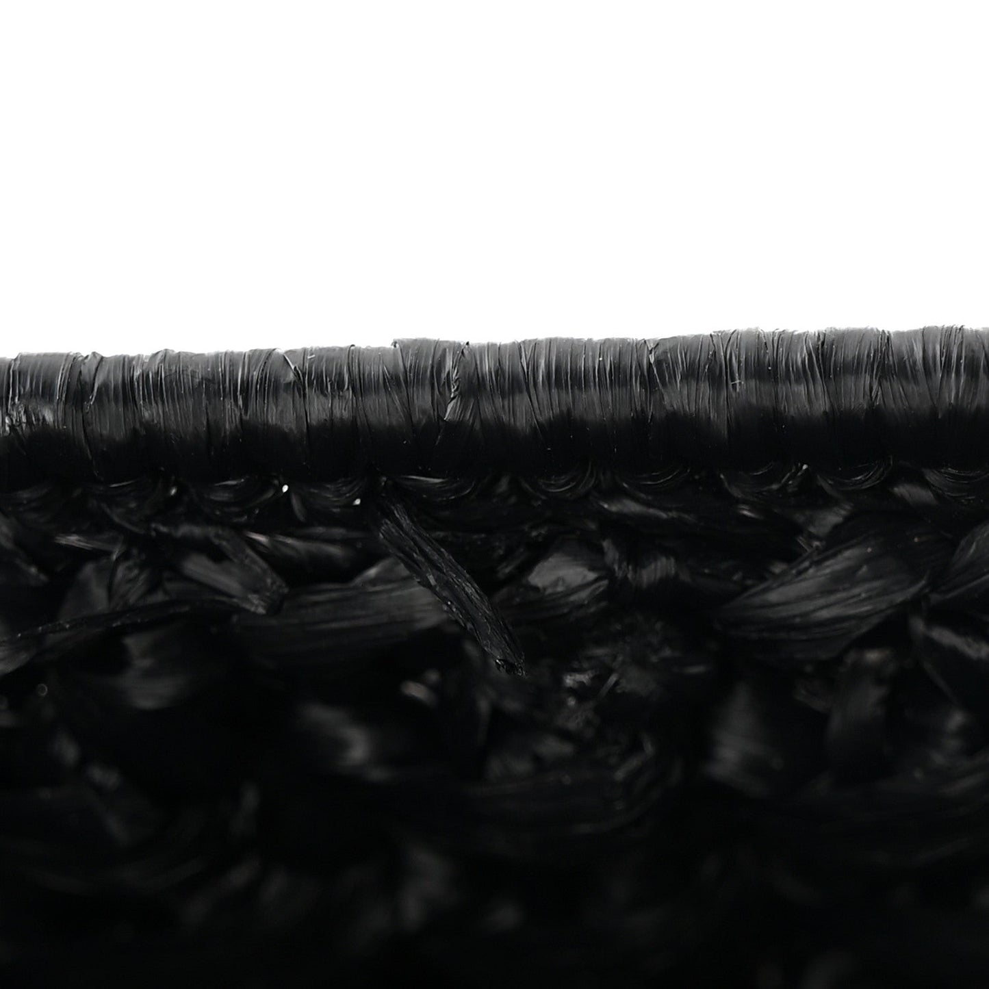Close-up of black woven raffia-effect texture on the bag surface