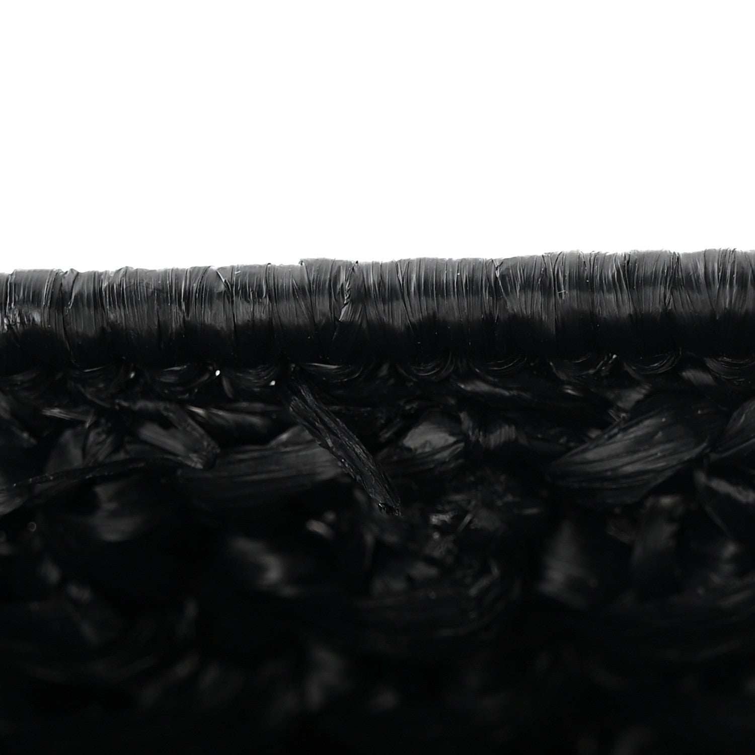 Close-up of black woven raffia-effect texture on the bag surface