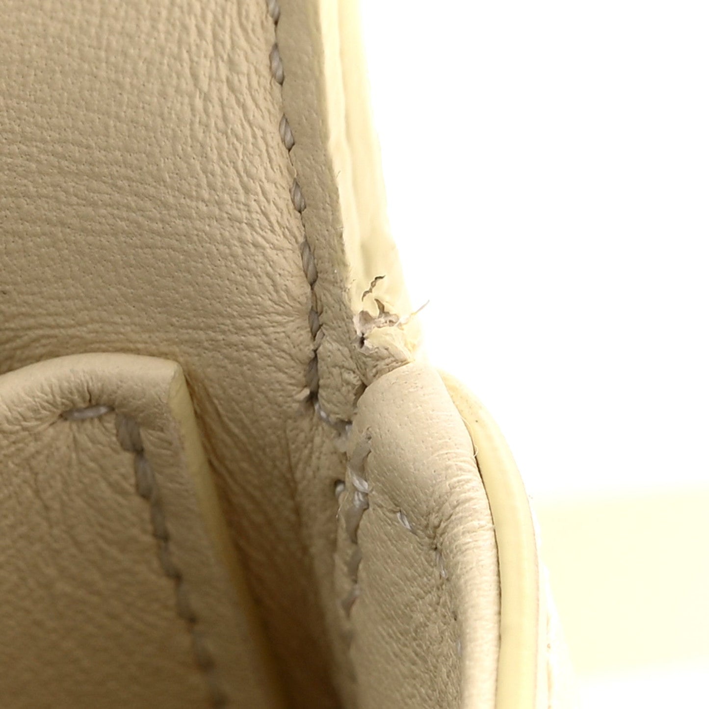 Close-up of nude calfskin side seam and stitching detail on the bag