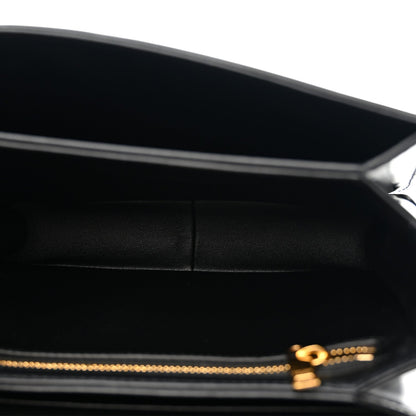 Black leather crossbody bag interior view with gold zipper pull and logo detail.