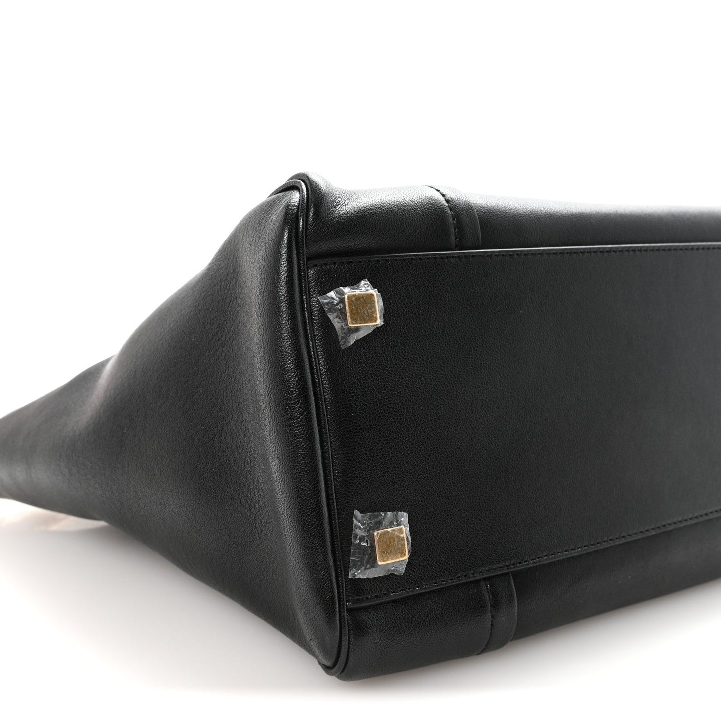 Black leather bag corner with gold-tone snap hardware.