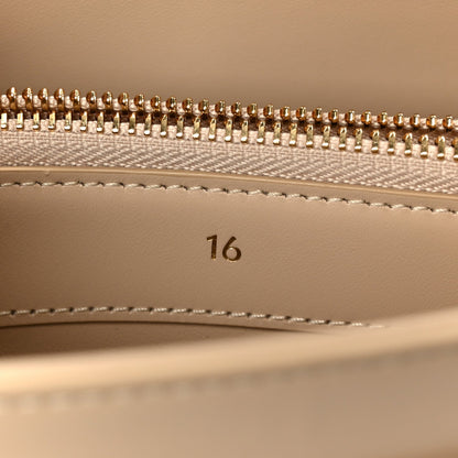 Gold zipper teeth and beige lining with stitched seam inside a small bag