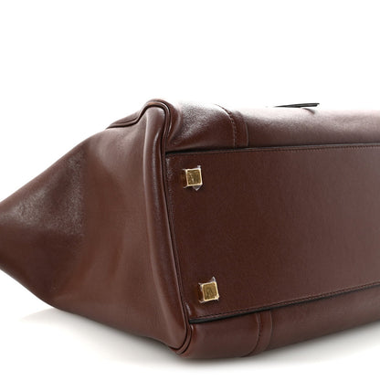 Dark brown lambskin handbag corner with gold-tone square stud and reinforced seam