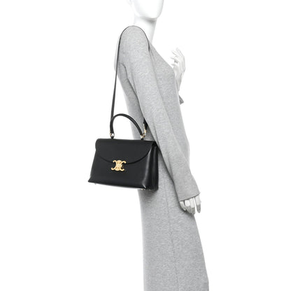 Black leather handbag with shoulder strap and small gold C logo on front flap