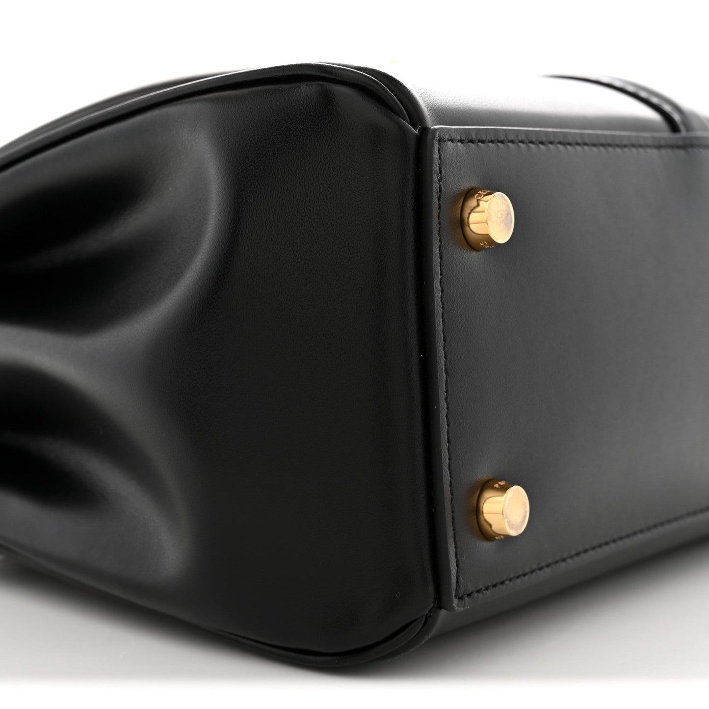 Black leather side panel with gold snap studs and sculpted bag corner