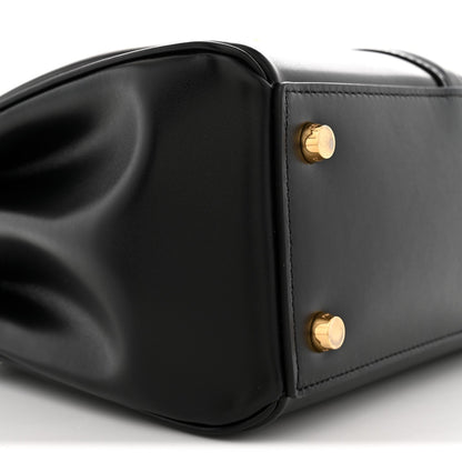 Black leather side panel with gold snap studs and sculpted bag corner