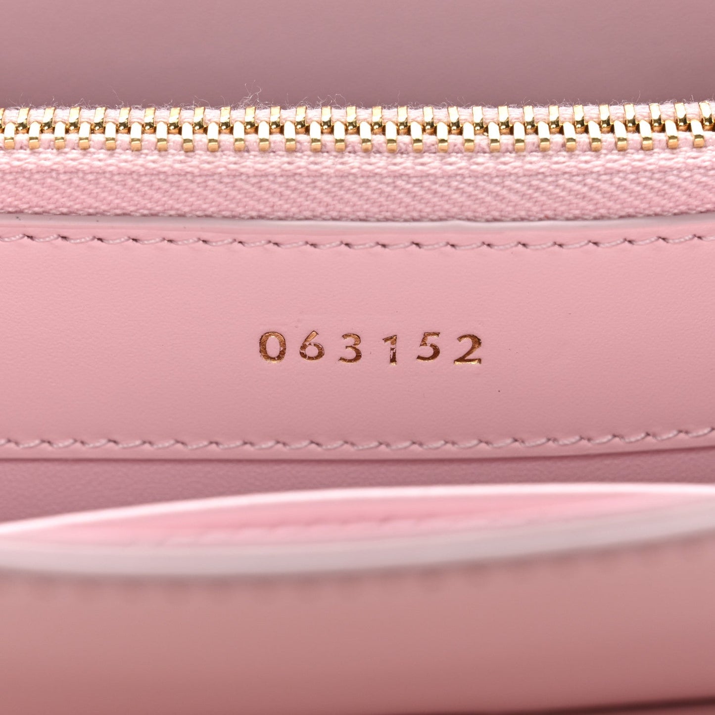 Pastel pink mini bag interior with gold zipper and stamped code 063152
