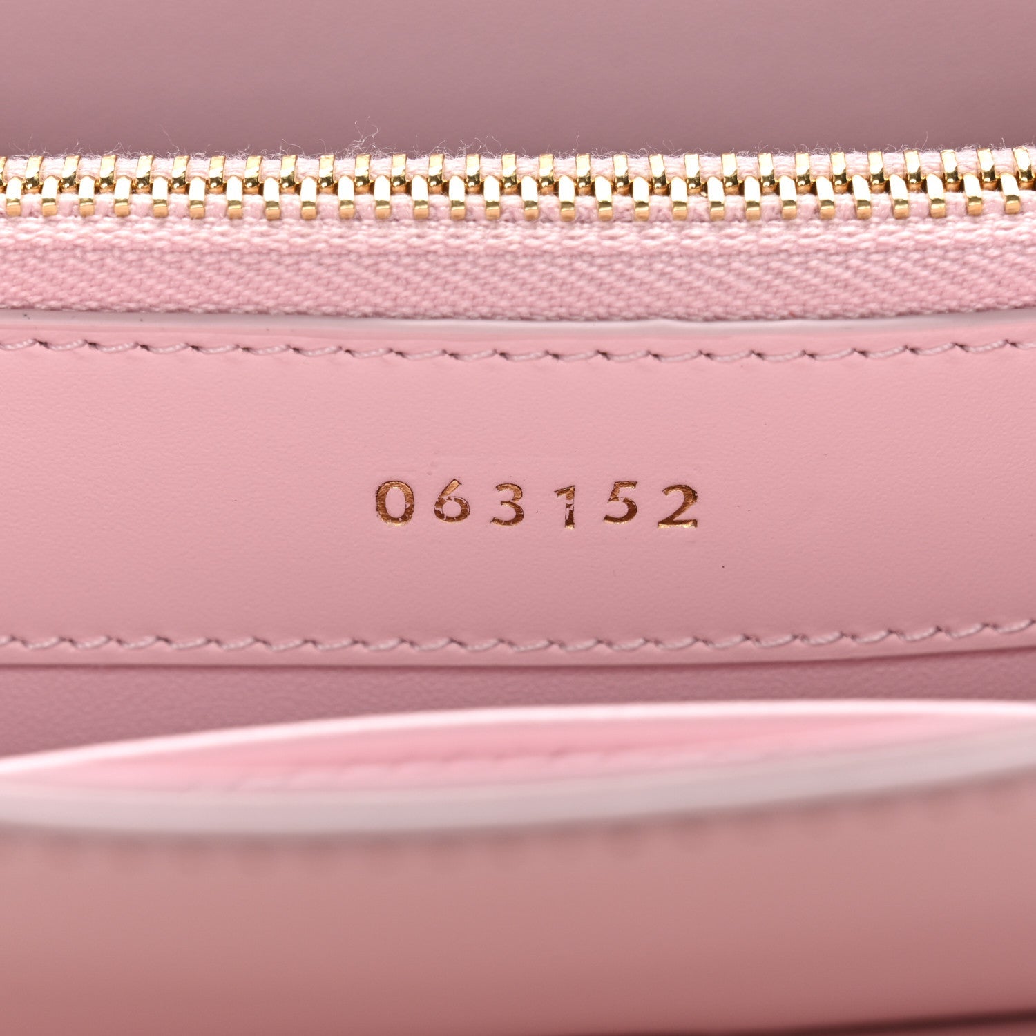 Pastel pink mini bag interior with gold zipper and stamped code 063152