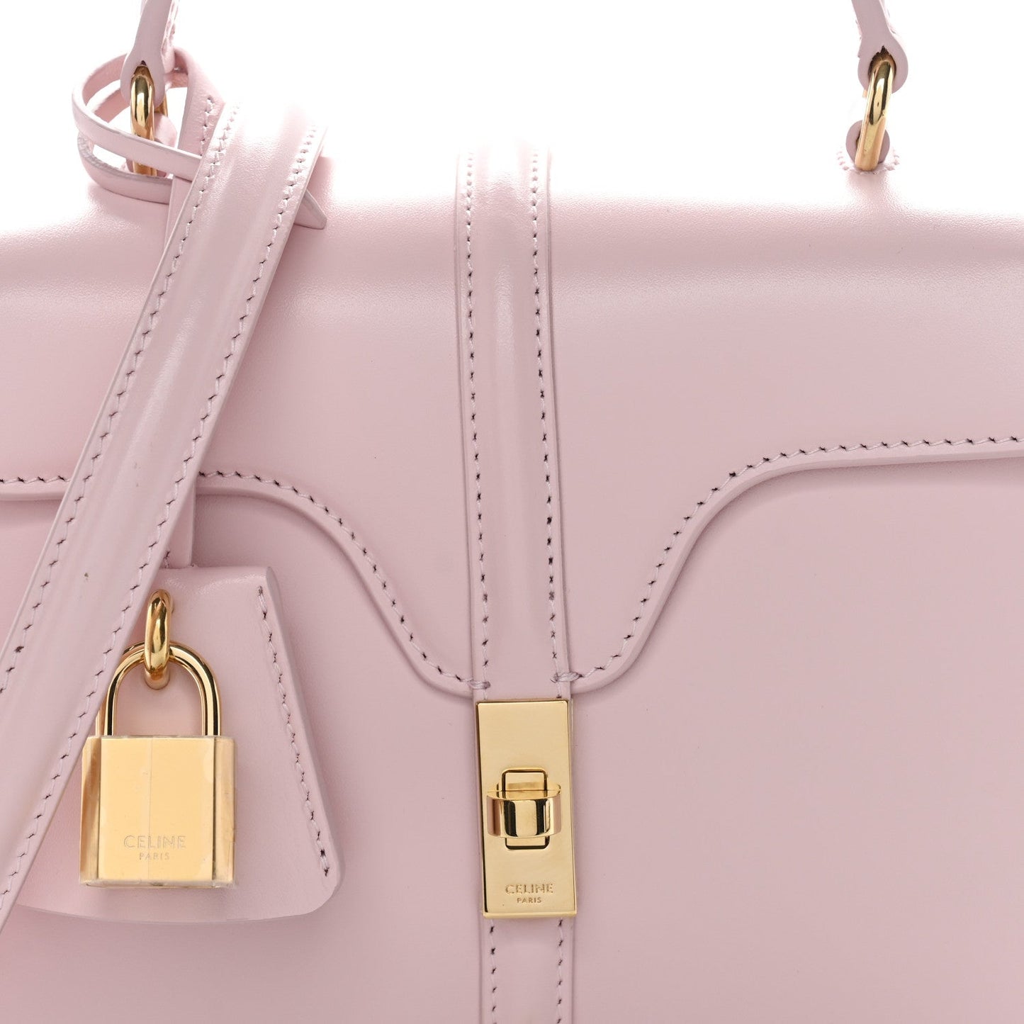 Pastel pink mini top-handle bag close-up with gold padlock charm and front clasp