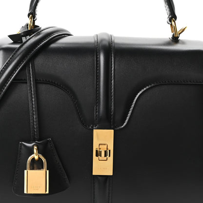 Celine mini bag front detail in black leather with gold lock and decorative padlock charm