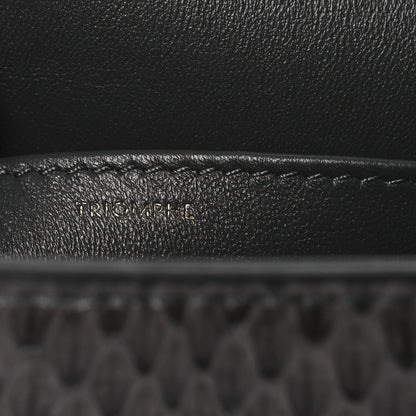 Grey snakeskin shoulder bag flap close-up with embossed brand detail
