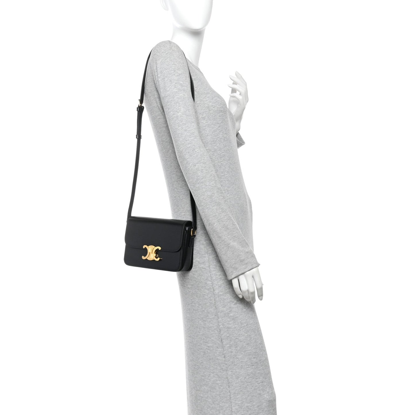 Black mini shoulder bag on model with gold logo, worn crossbody with slim strap.
