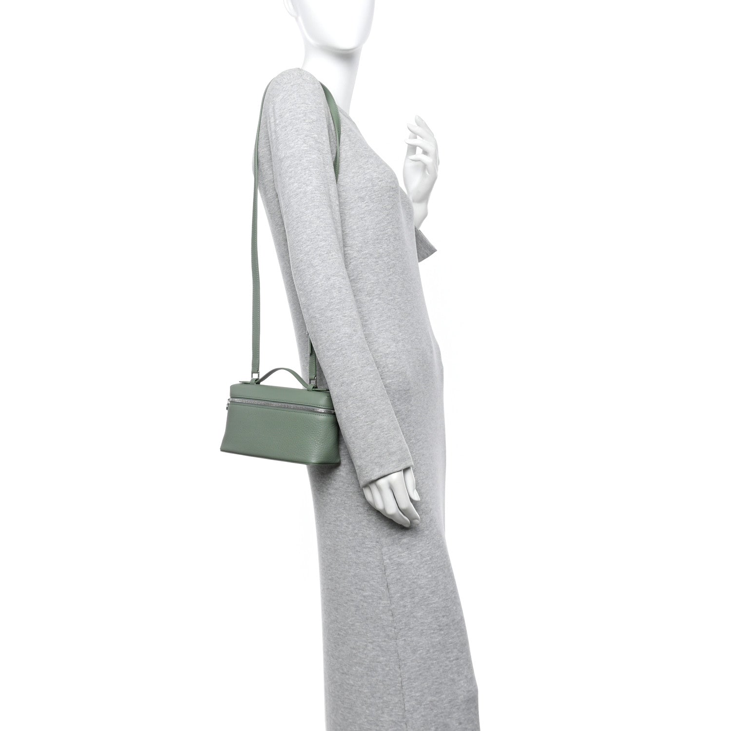 Sage green leather mini pouch with crossbody strap, worn at side
