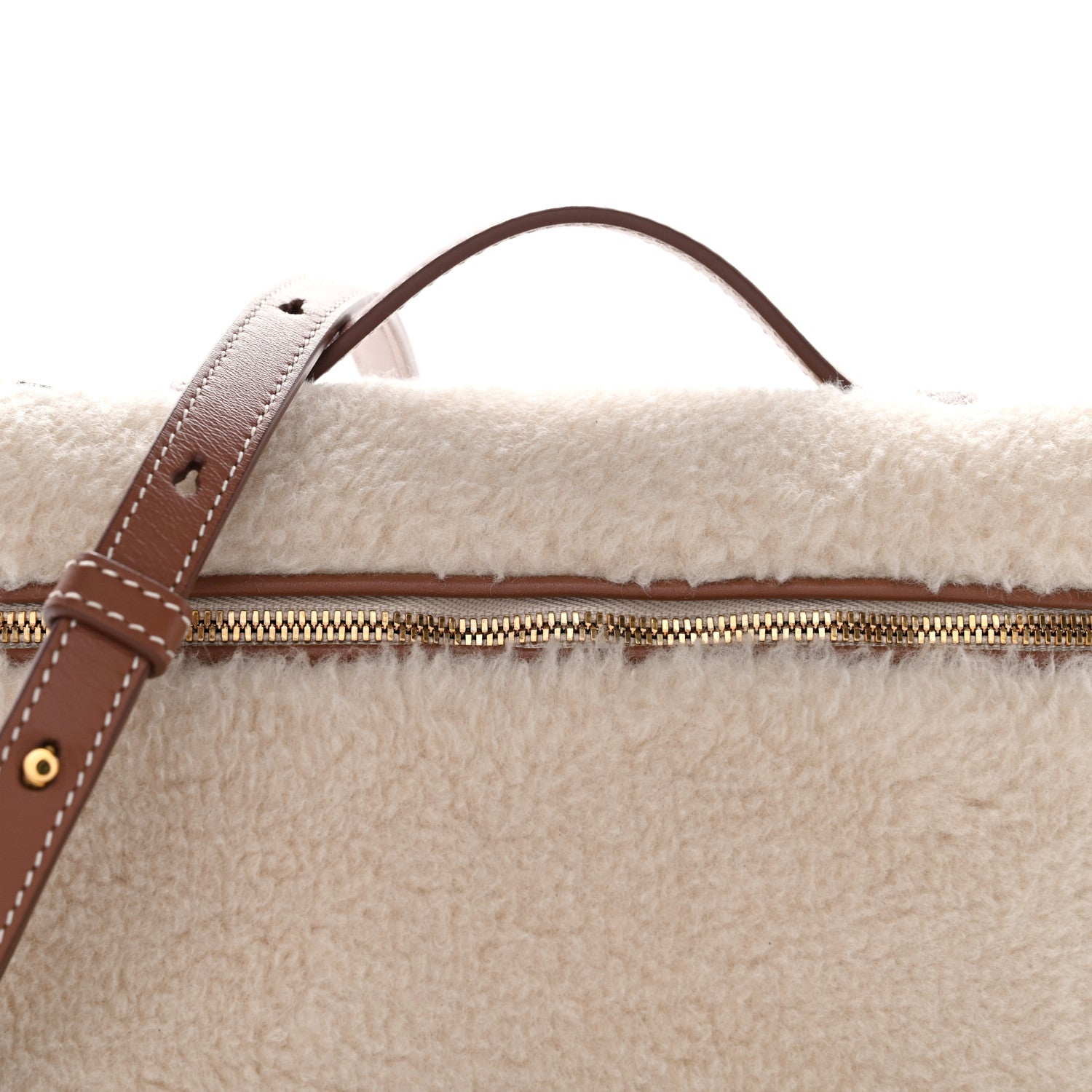 Top view of cream faux-fur pouch with brown leather handle and gold zipper