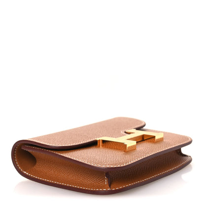Constance slim wallet angled view in textured tan leather with gold-tone closure hardware