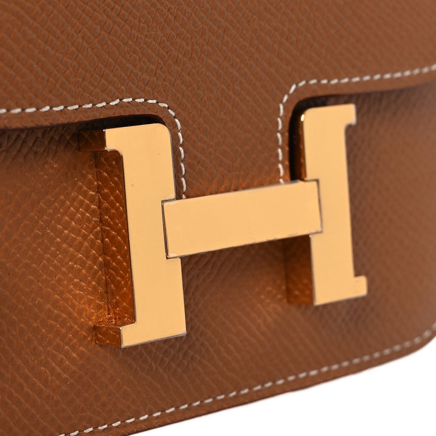 Constance slim wallet close-up of gold-tone H clasp hardware on tan leather flap