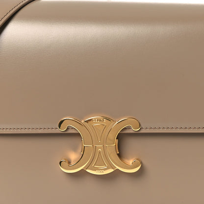 Gold Triomphe clasp emblem on shiny beige leather flap