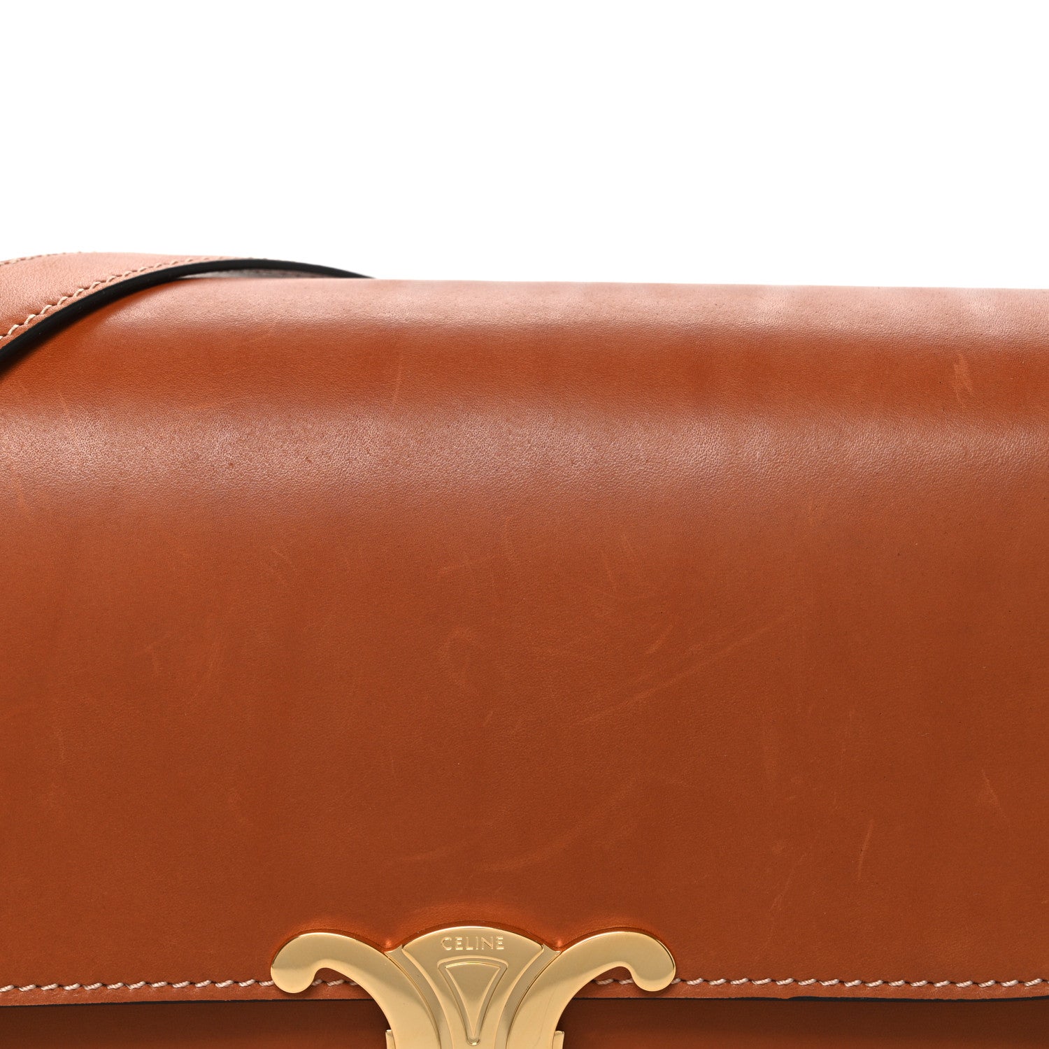 Tan shoulder bag flap with gold-tone Celine emblem and braided edge stitching.