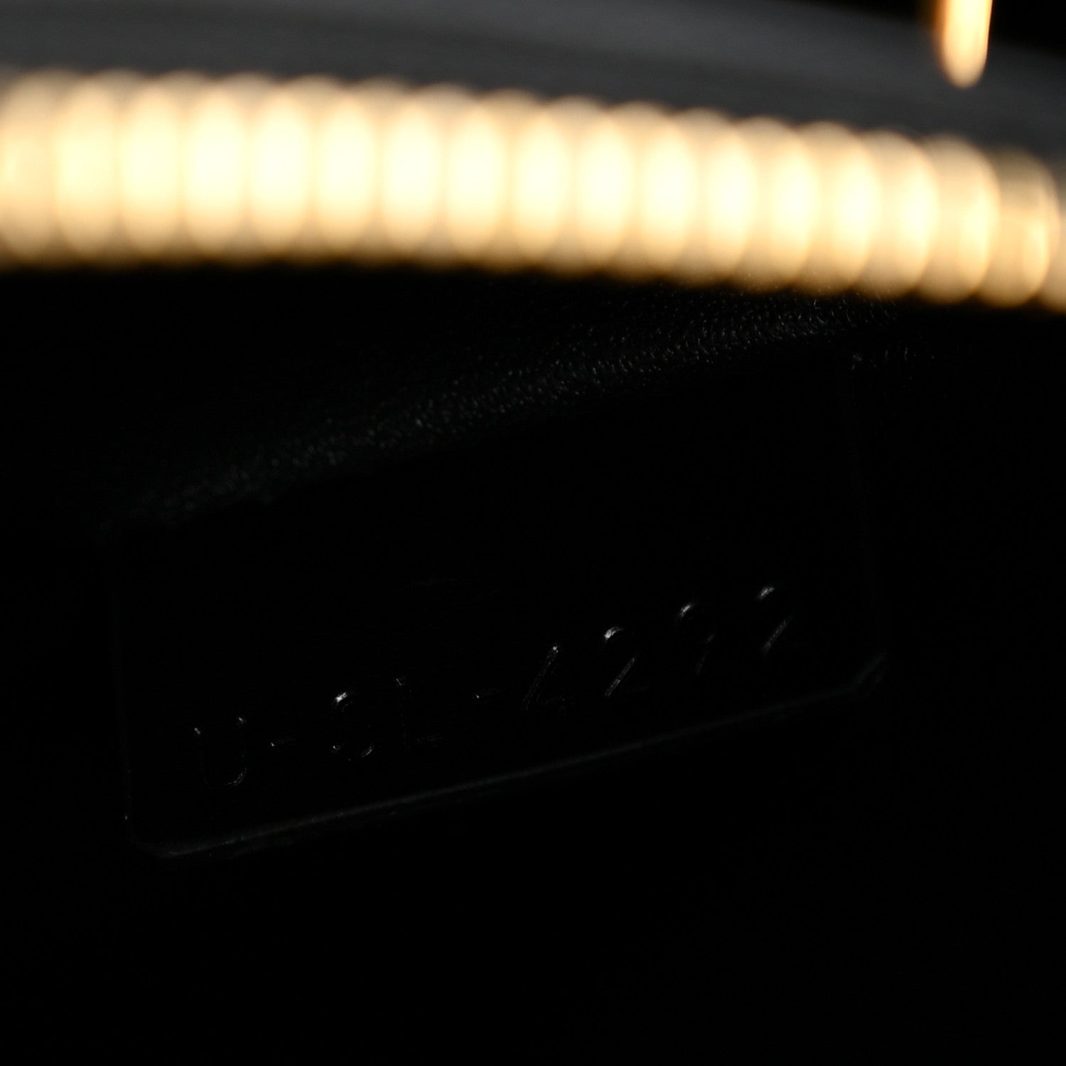 Black leather interior panel with stitched detail and dark opening edge