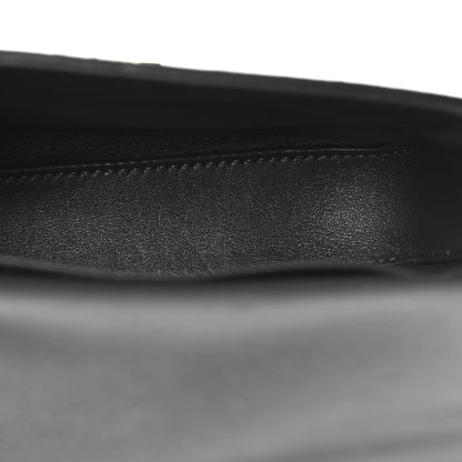 Close-up of black leather strap edge on grey snakeskin shoulder bag