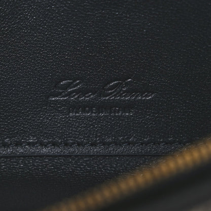 Embossed Loro Piana logo on dark navy leather flap with visible stitching