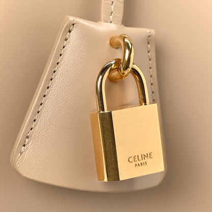 Gold padlock clasp on nude leather bag with looped strap hardware