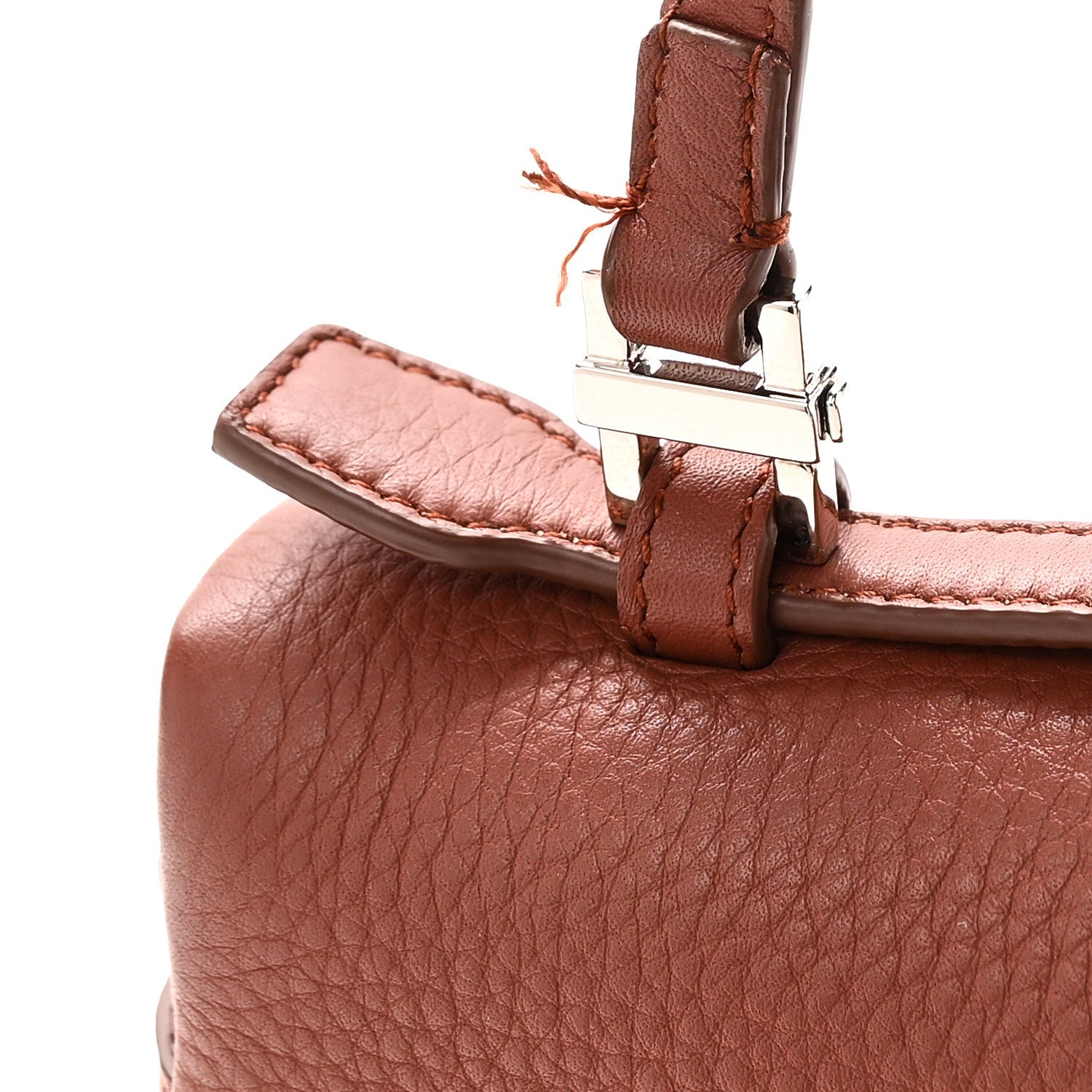 Leather strap buckle and metal clasp on grained calfskin pouch