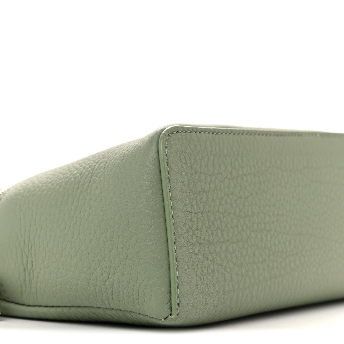 Sage green grained calfskin pouch corner with stitched seam, close-up