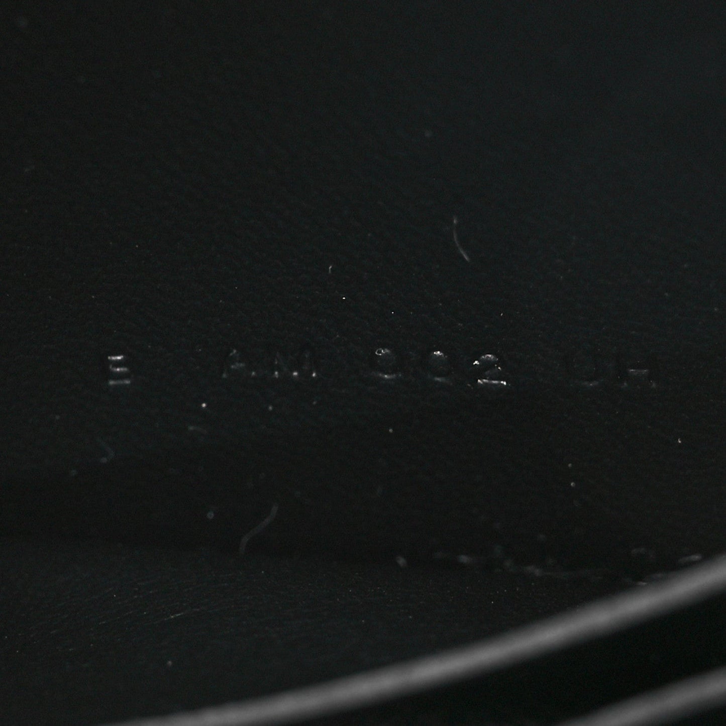 Black leather wallet exterior with faint stamped markings