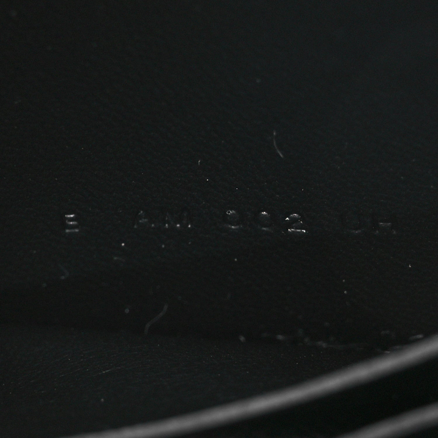 Black leather wallet exterior with faint stamped markings