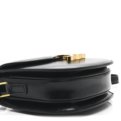 Black leather crossbody bag with gold-tone top clasp and front strap detail
