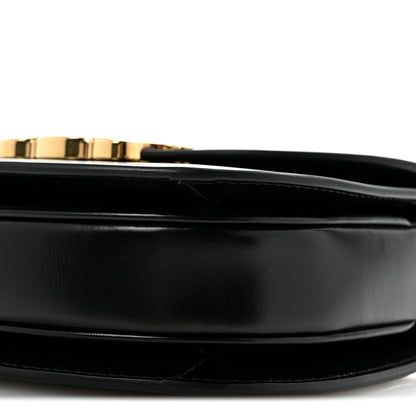 Black shiny calfskin mini crossbody bag, gold trim and top edge close-up