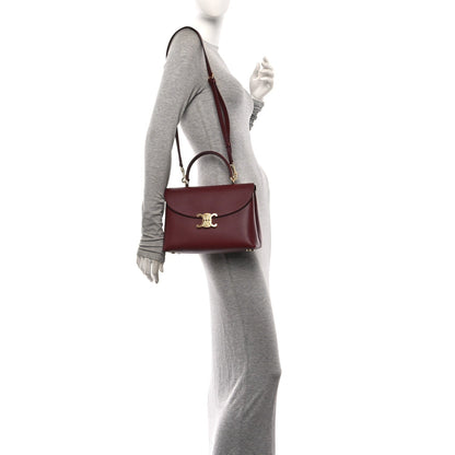 Celine burgundy leather shoulder bag worn on model, single strap and logo clasp