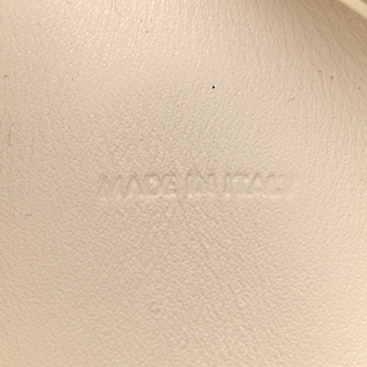 Light rice cream leather surface with faint embossed branding
