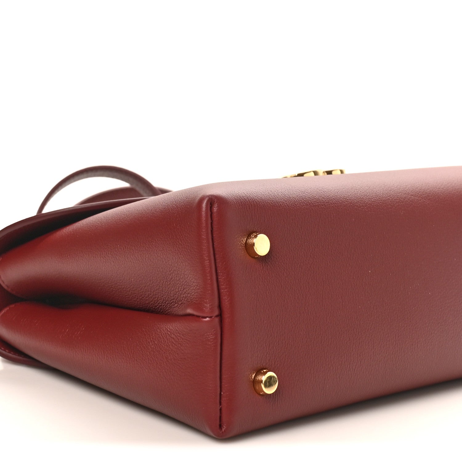 Celine burgundy leather bag corner with gold side studs and curved seam detail
