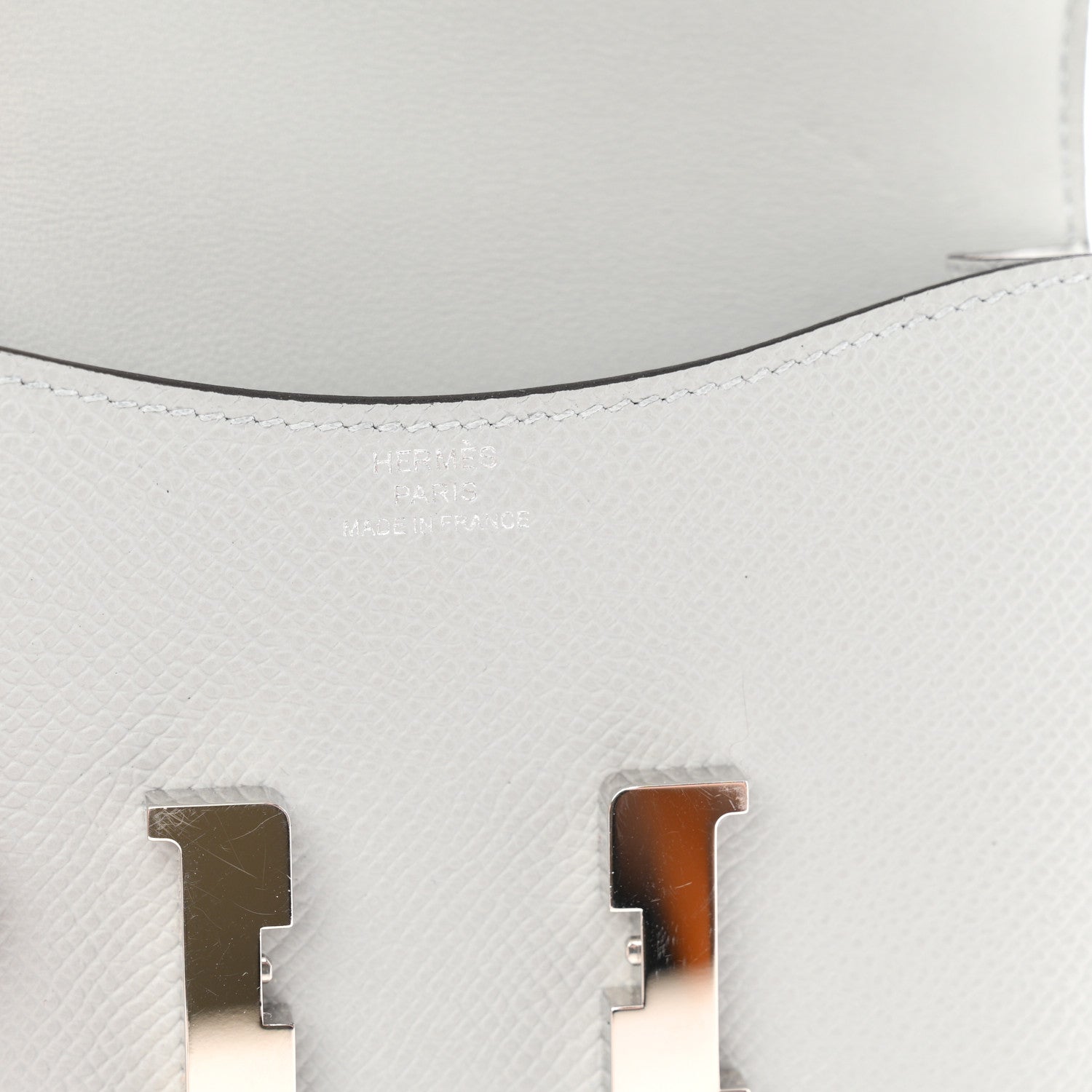 Hermes Constance slim wallet close-up, light blue leather and silver H turn-lock.