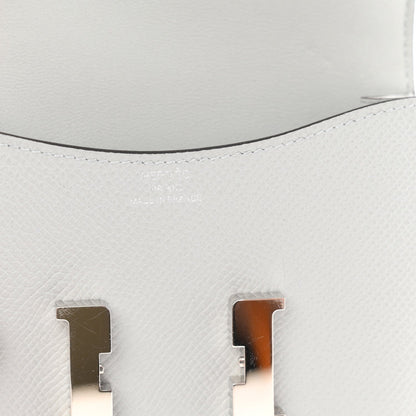 Hermes Constance slim wallet close-up, light blue leather and silver H turn-lock.