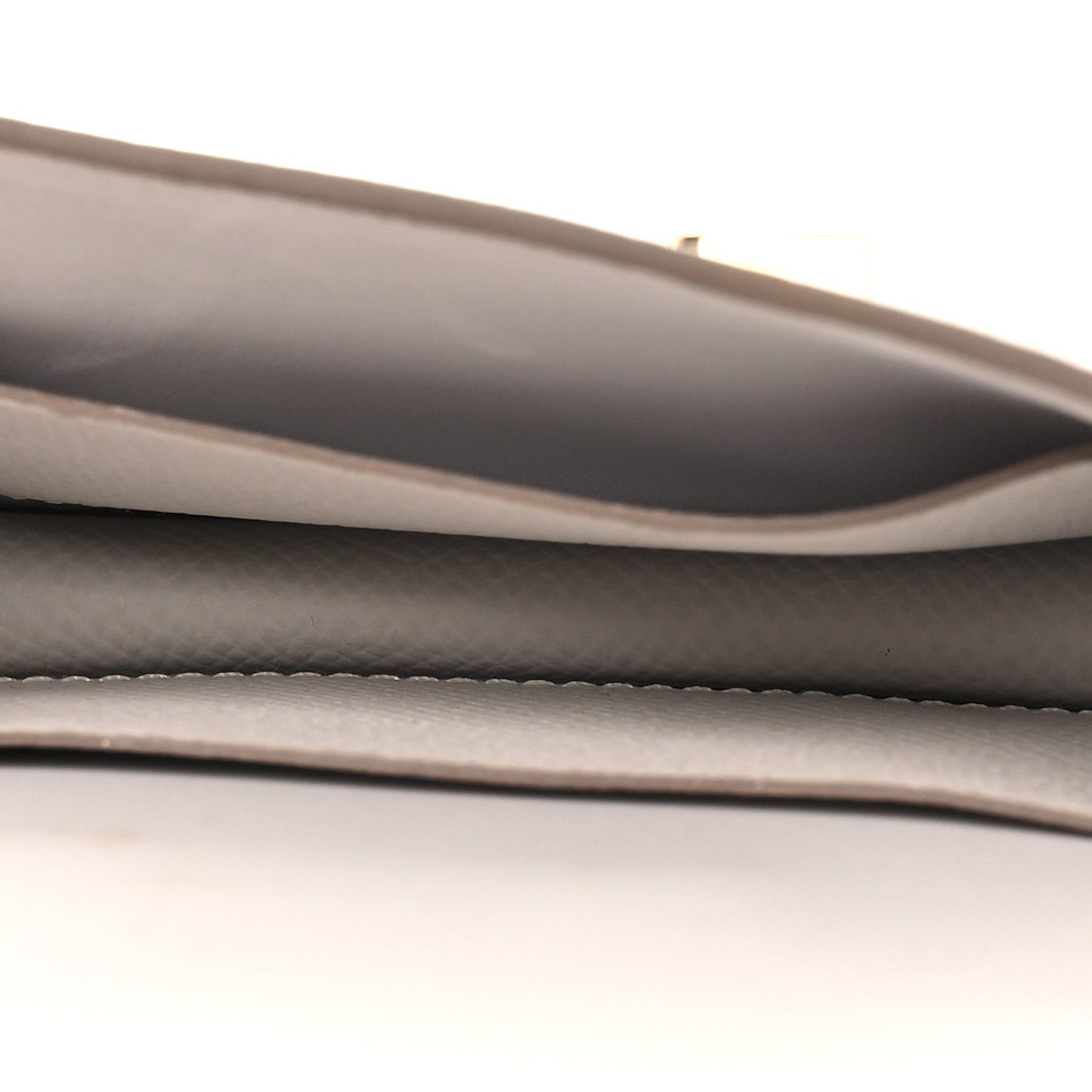 Pale gray leather wallet interior edge with smooth lining and layered seam