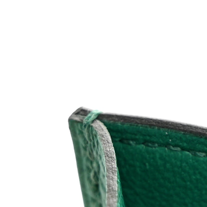 Green leather wallet corner with stitched edge and folded seam detail