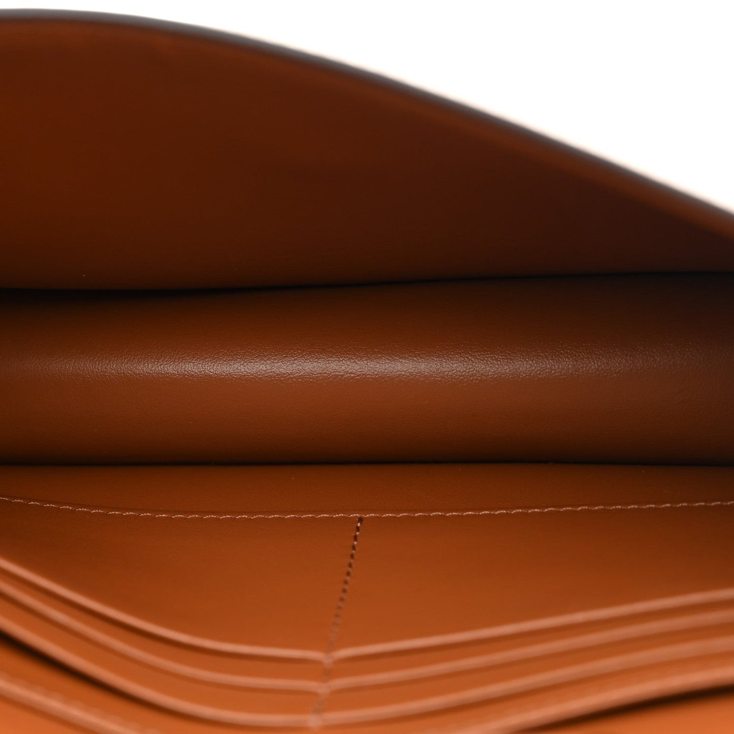 Close-up of tan/brown leather wallet surface with visible seam stitching